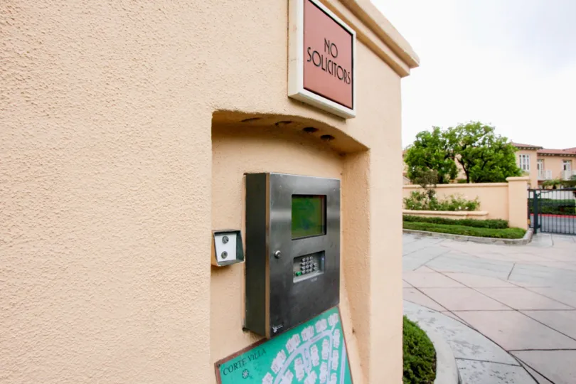A sign reading "No Solicitors" sits above a callbox at the Corte Villa townhomes