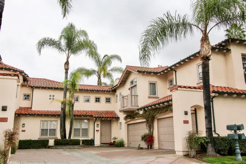 A sunny day in the area of Corte Villa, outside, palm trees, garages, flowers, door