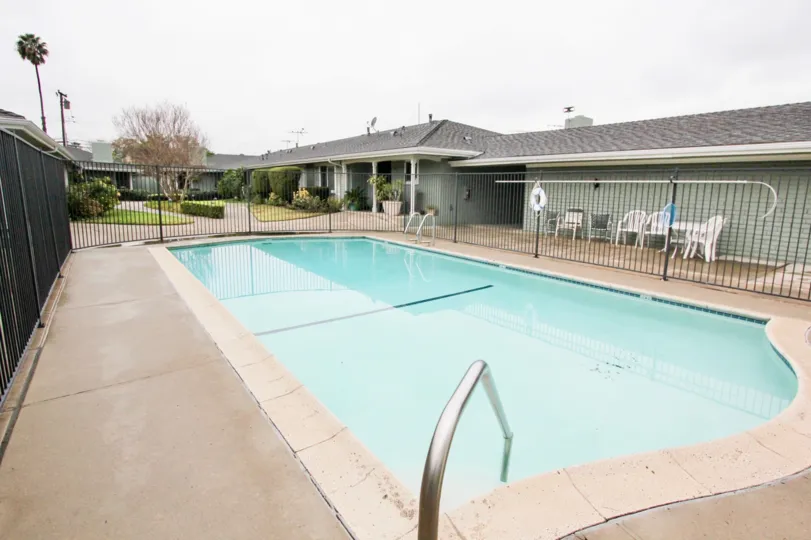 THIS Image represents the beautiful swimming pool which have the lot of chairs and views the longsite trees plants are there in the city of Tustin