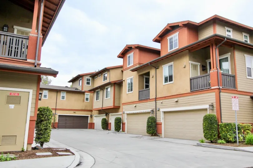 An overcast day by a Lindy Crossing complex with multiple garages and bushes in between each garage door