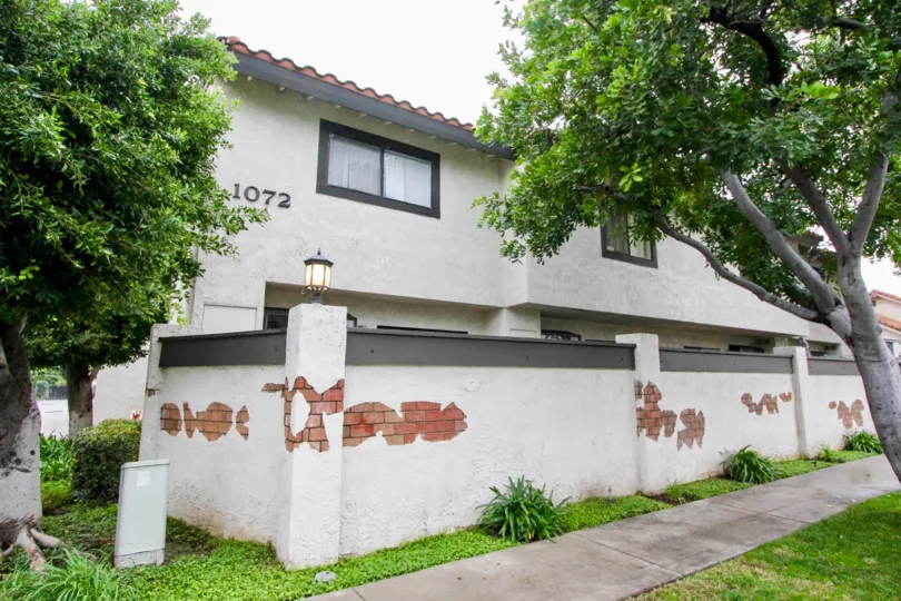 Well-maintained common area walkways and mature landscaping at the Macaw Cove community