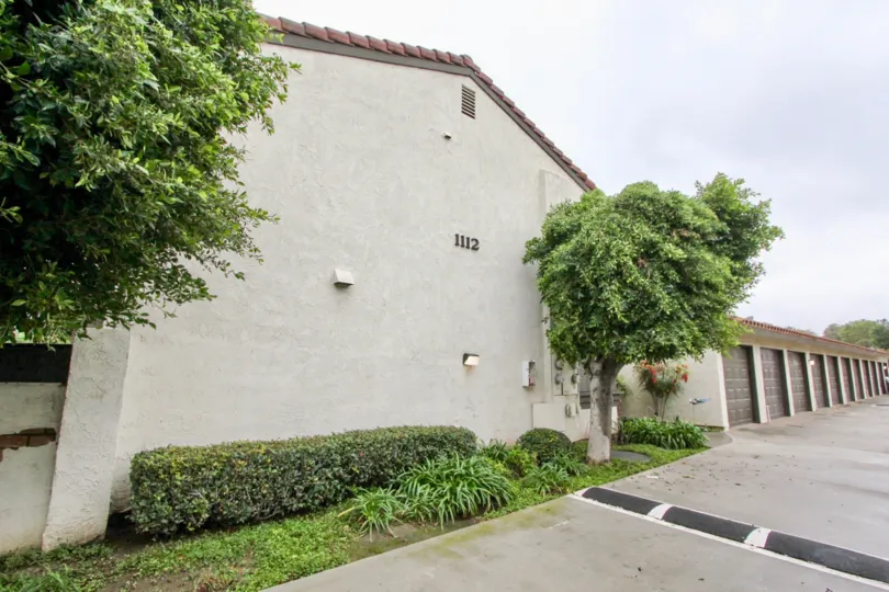 Backlane with speed bump and attached single car garage units for residents of Macaw Cove