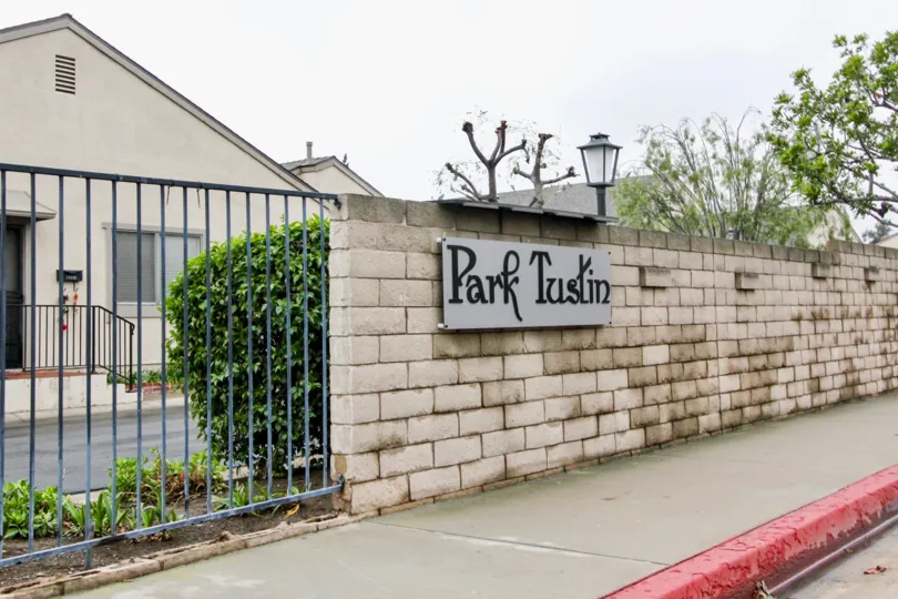 THE FLAT IN THE PARK TUSTIN WITH THE PARK TUSTIN BOARD, LIGHT, PLANTS, GATE