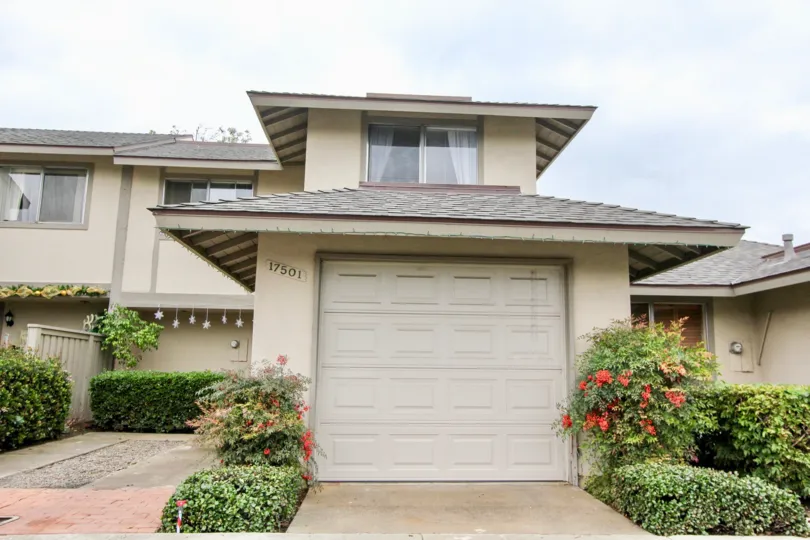 2 Storey attached home with single car garage and well maintained hedges and shingle roofs in Tustin