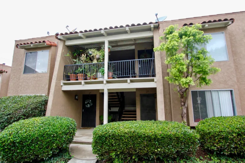 A simple two-storey townhouse with a covered balcony in the Rancho San Juan community.