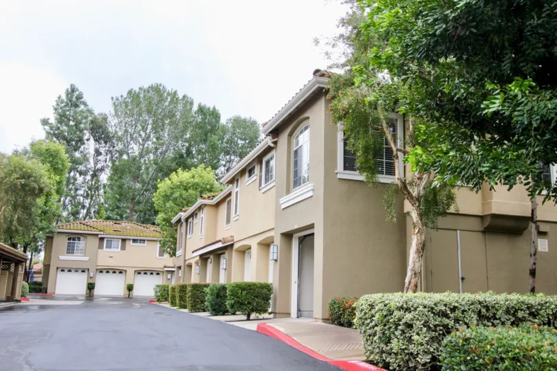 An olive green townhome sits next to row of tan ones in the Shadow Canyon community