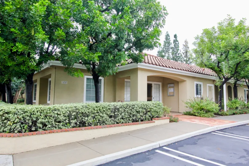 A bungalow with tile roofing in the Shadow Canyon community surrounded by trees.
