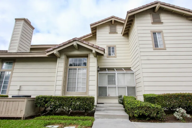 Two-storey residence with wooden cladding and brownish paint in the Sycamore Glen community.