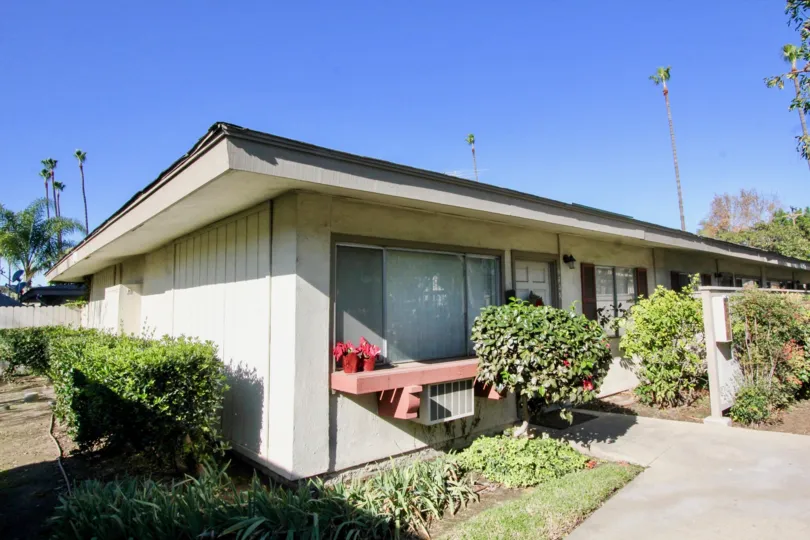 THE HOUSE IN THE TUSTIN ACRES WITH THE AIR CONDITIONER, PLANTS, TREES