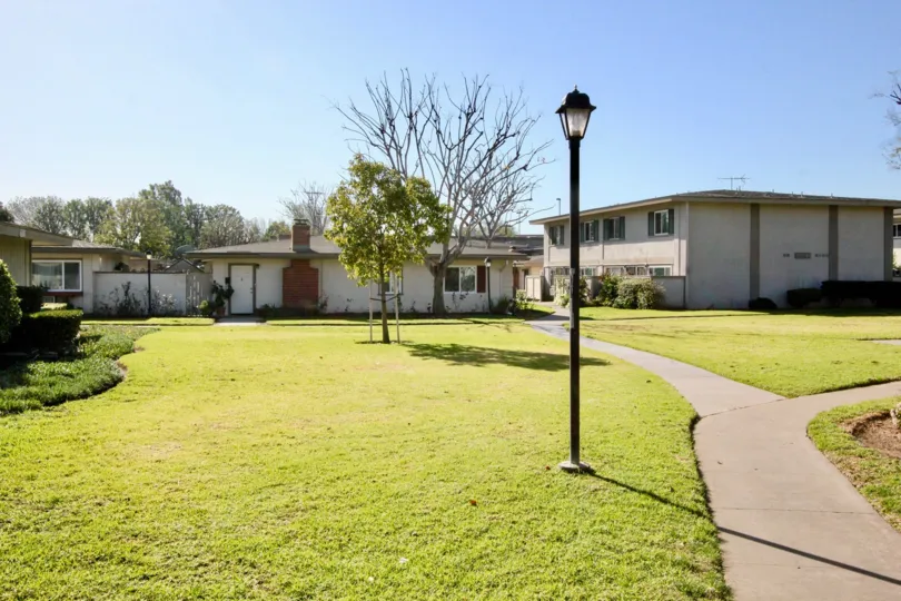 a sunny day in the tustin acres with building that has garden in the front of top out post and more windows