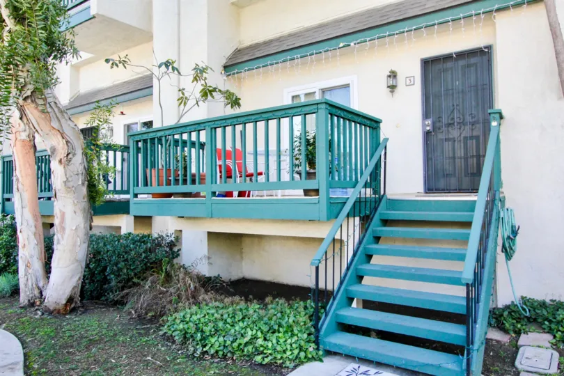Wooden stairs and fence on a town home have been painted teal in the Tustin Commons