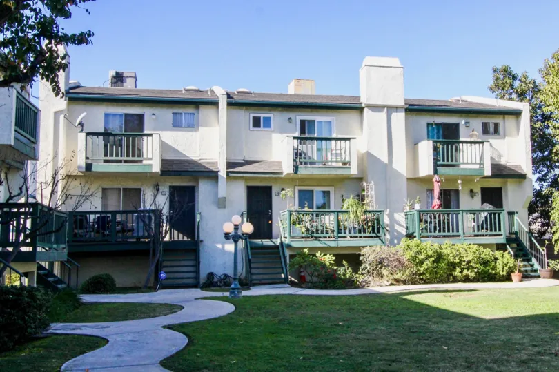 THIs beautiful home with excellent lawn is in the city of Tustin that has the light lamp, small plants, pathway to the home and the trees, steps, glass windows are there