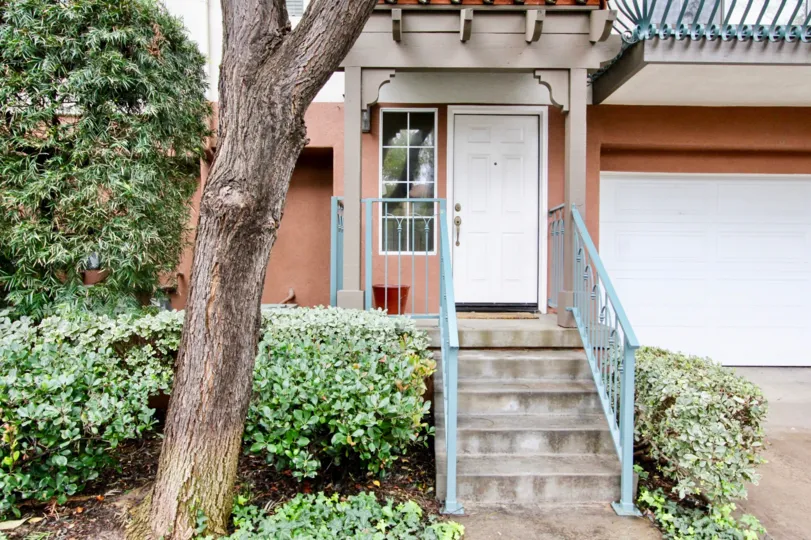 An empty red planter sits next to a white door in the Tustin Del Verde community