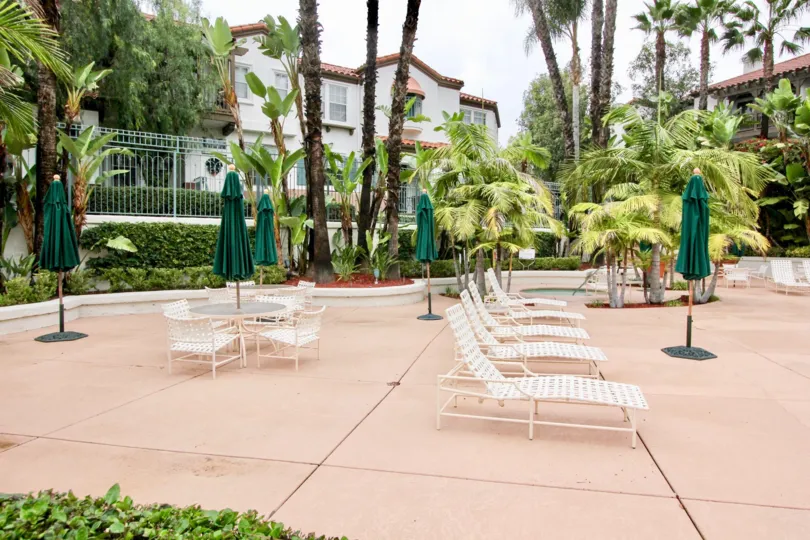 A public lounging area with closed umbrellas in the Tustin Del Verde community.