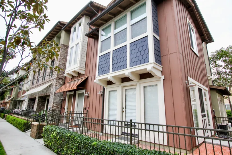 Blue shingles contrast a brown paneled wall in the Tustin Field community