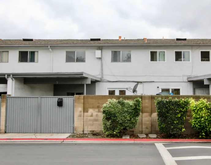 Two-storey townhouses with plain white walls and sliding windows in the Tustin Imperial community.