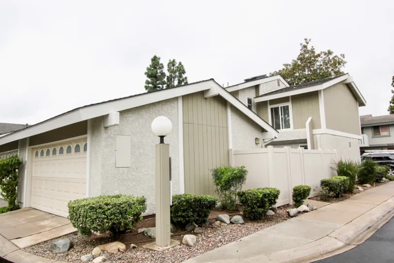 A white round bulb sits on top of a lamp post near a townhome in the Tustin Pines community