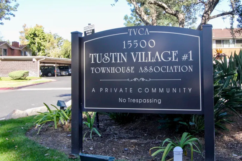 THE FLATS IN THE TUSTIN VILLAGE WITH THE ADDRESS BOARD, PLANTS, TREES, CAR PARKING