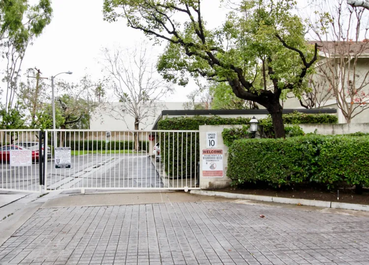 A sign near a gate warns drivers the speed limit is 10 miles per hour at the Village Homes