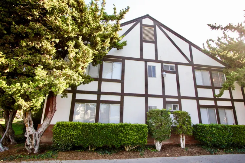 a warm day in the williamshire condos with abuilding that has roof less top and garden around