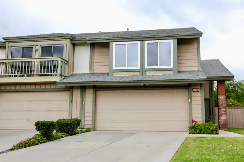 A two story Charter Hill apartment with garages on a cloudy day.