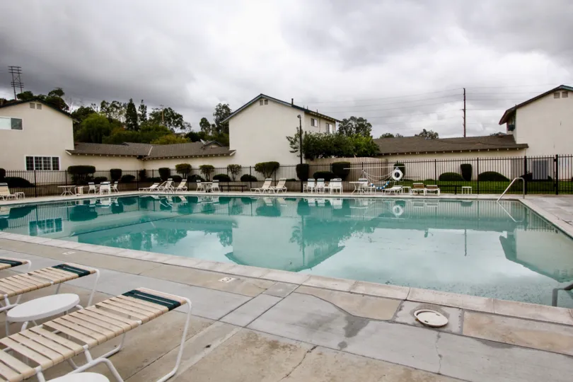 In Fairgreen Homes, Swimming pool with seating tables, chairs and with villa's and trees
