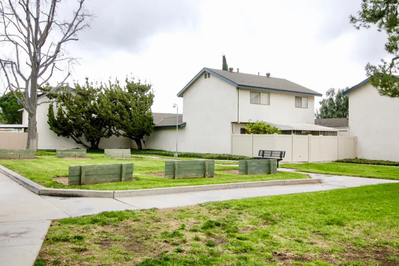 A lawn in the Fairgreen Homes community with benches on a cloudy day.