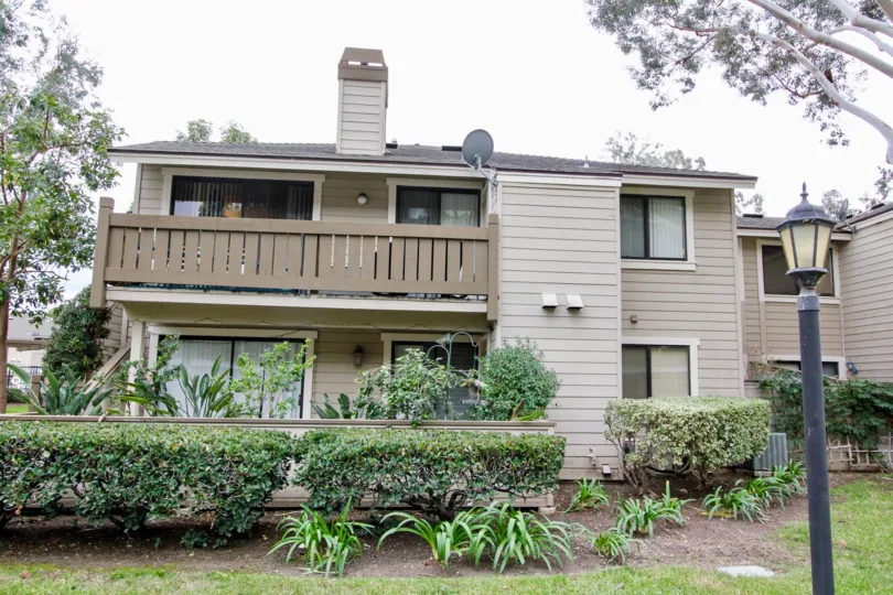 A front view of an elegant bunglow with a large balcony and a garden inside Kellogg Terrace community