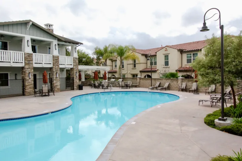 IN each table there is a umbrella is closing near the swimming pool in Palisades at Vista Del Verde