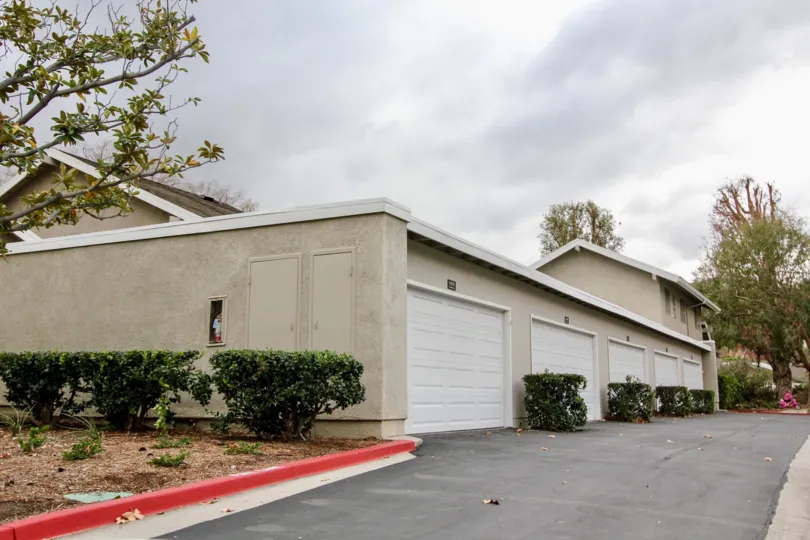 The road in Rancho Dominguez Townhomes has few villa's with car shed and bushes with trees