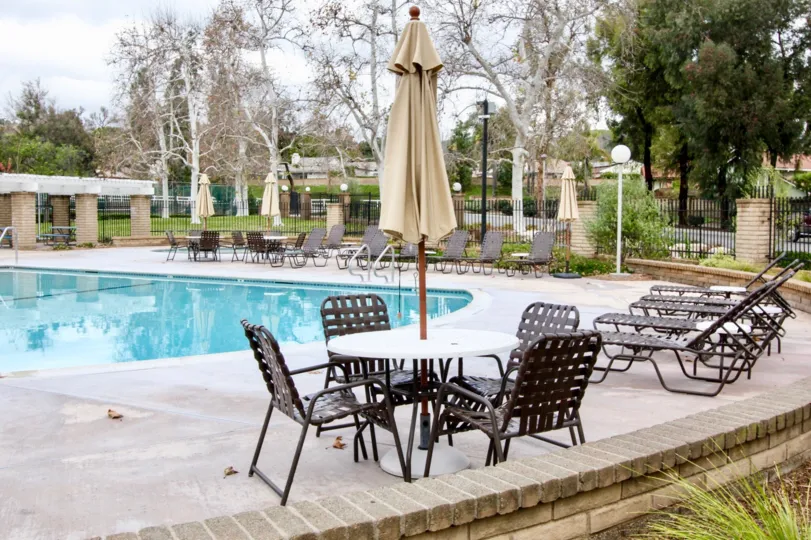 The sunny day in the Rancho Dominguez Townhomes with swimming pool and chairs.