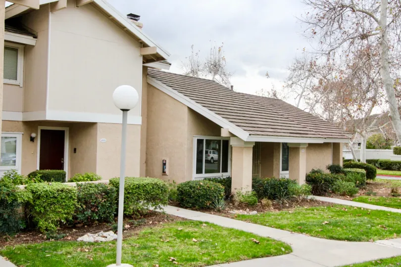 Front yard with lanscaping an tan housing area located in Rancho Dominguez Townhomes.