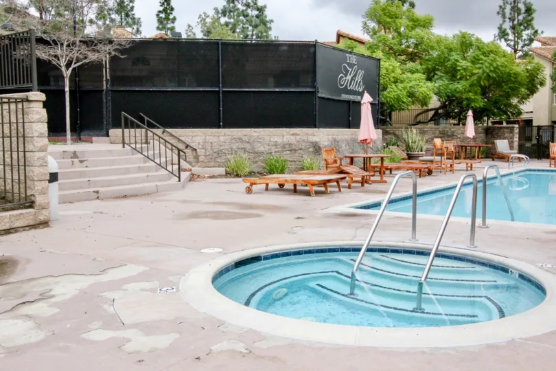Two pools with wood chairs and plants around it at the hills community in yorba linda, california.