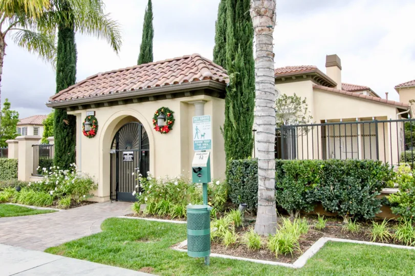 A gate to the Villaggio community with Christmas wreaths and other plants.