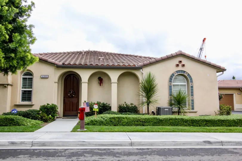 A home in Villaggio community in Yorba Linda, California with a santa clause sign in the yard and a red bow on the mailbox.