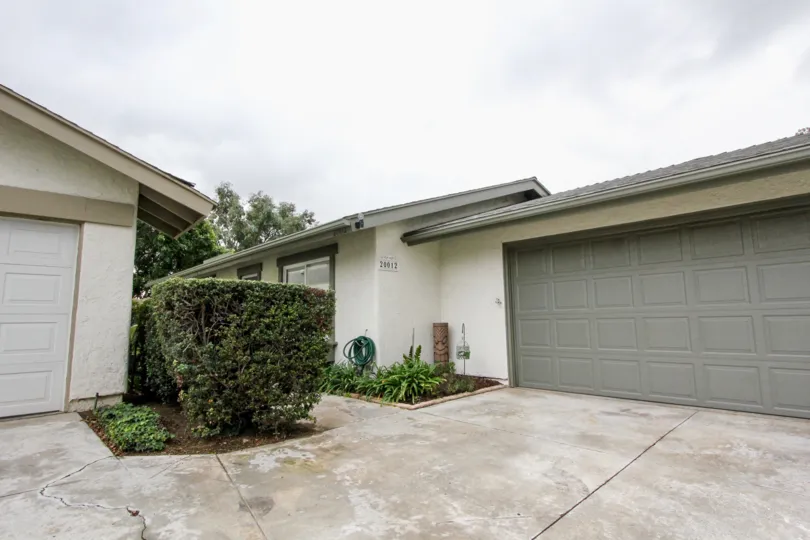 Driveway to two homes in Woodgate with garages on a cloudy day.
