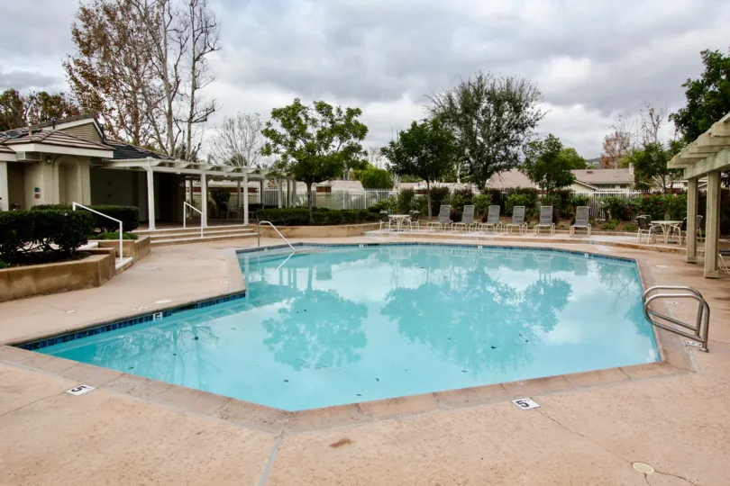 Yorba Meadowood Yorba Linda California swimming pool reflecting images of tree and sky in a cloudy time