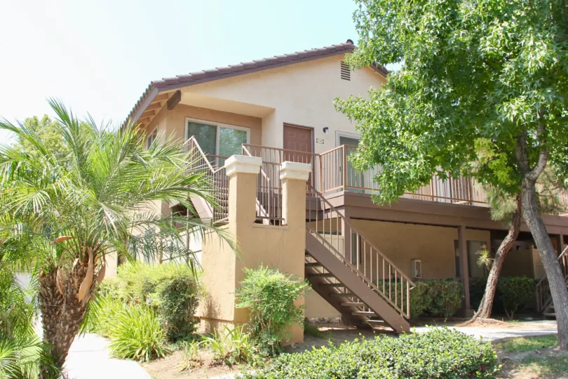 Garden landscaping with palm trees and stairs up to the condo entrance
