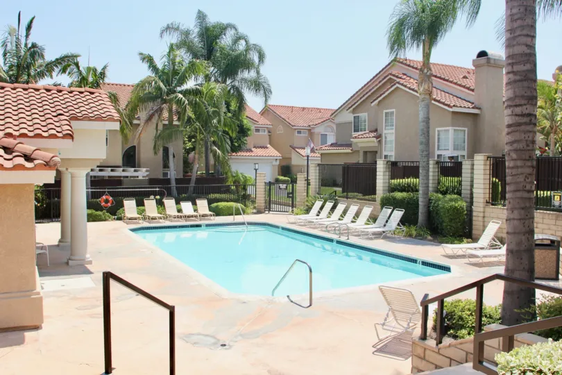 Apartment with swimming pool in Corona CA. Sunny day with palm trees.