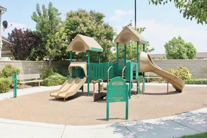 A sunny day in theHampton Roads playing park in front of house with children's playground and tables to be set and relaxed