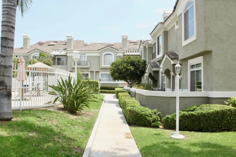 A walkway next to the pool in the rear of the community homes in the beautiful green community of Laing's First Edition Community in Corona, California.