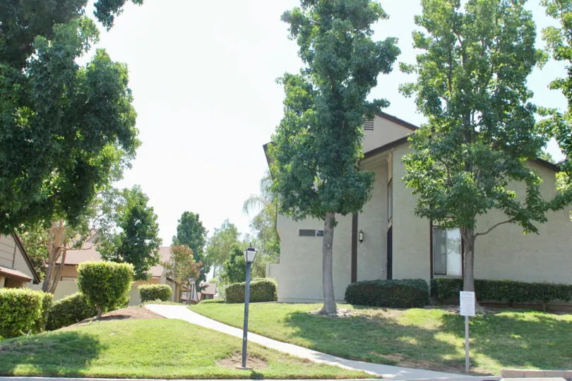 Whiten painted amazing apartment with beautiful lawn on a sunny day in Laurelwood neighborhood