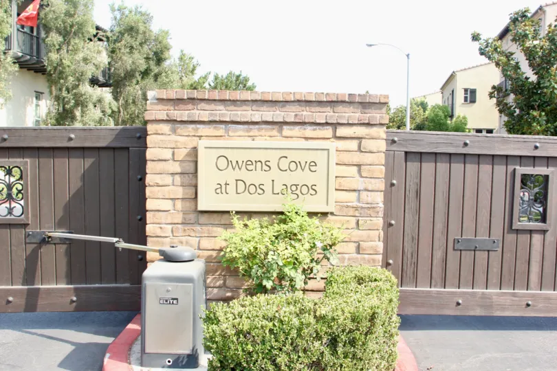 Close up of sign and gate of Owens Cove at Dos Lagos on Market Street in Corona, CA.