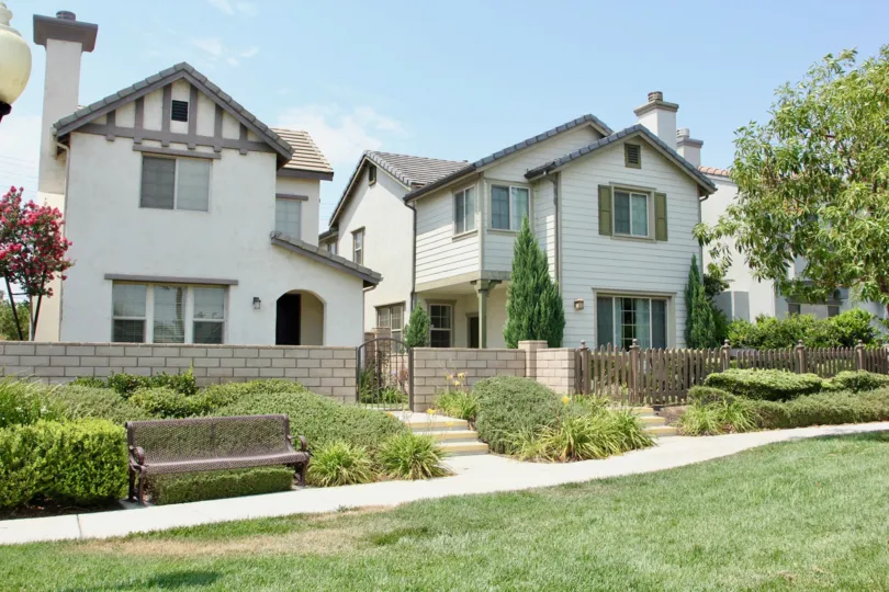 River Road Village corona California lovely building with pillar model, triangular roofing, tiny gate, blossoms