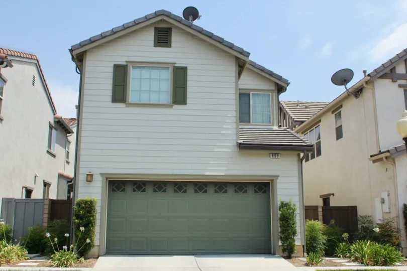 Single family house with large garage and two windows and landscaping