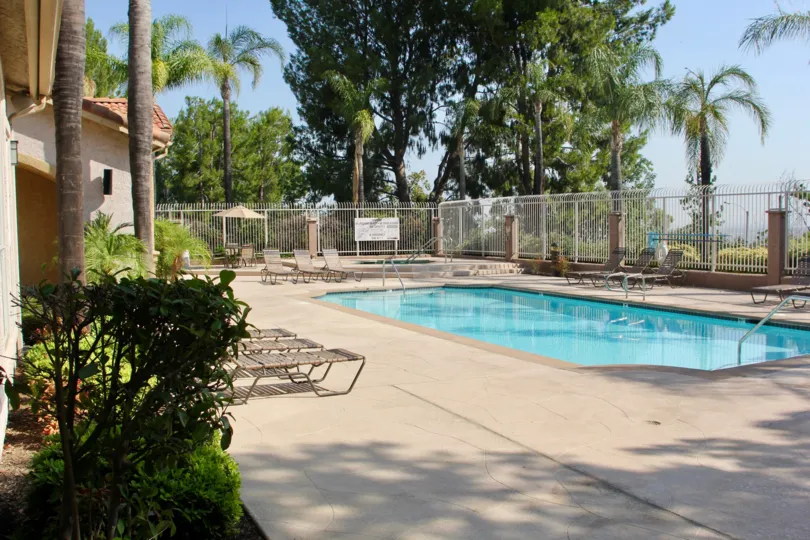 A white fence surround the community pool at Sage Canyon.