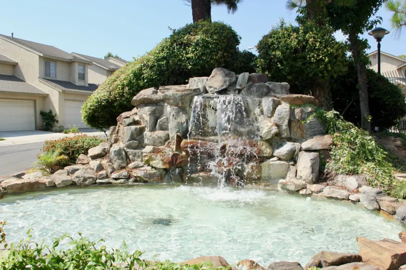 Water flows over stones into a fountain at the Santiago community.
