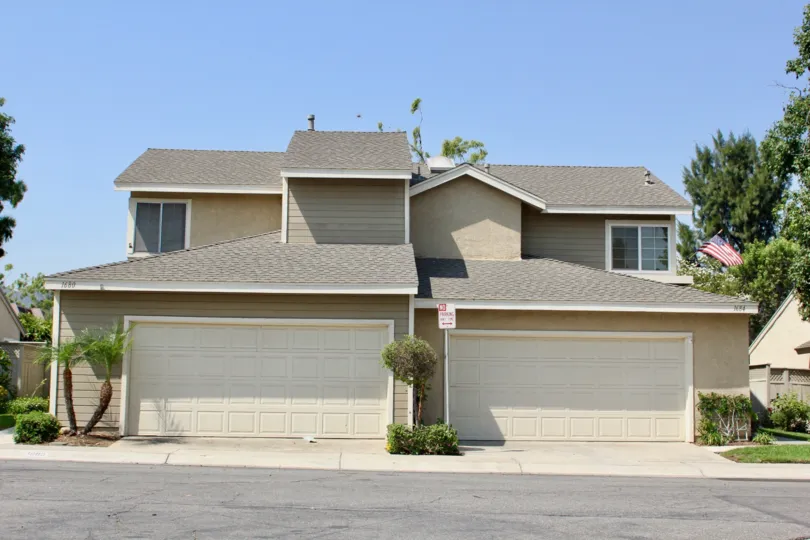 flag is placed at the top of the window near and door, window are closed and grasses are placed infront of house