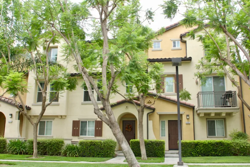 Beautiful jacaranda trees line this interesting condo building with spanish roof and decks