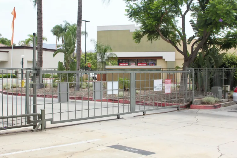 Trees behind metal gates in Sienna community in corona